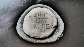 A stone with the words inscribed in clay in runic script: Hurrian Cult Legacy